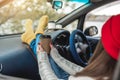 Woman in a car in warm yellow socks is holding a Cup of coffee in hands. Cozy autumn weekend trip. Freedom of travel Royalty Free Stock Photo