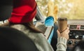 Woman in a car in warm yellow socks is reading a book while sitting in the passenger seat. Cozy autumn weekend trip Royalty Free Stock Photo