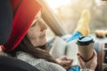 Woman in a car in warm yellow socks is reading a book while sitting in the passenger seat. Cozy autumn weekend trip Royalty Free Stock Photo