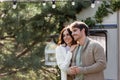 Woman in cardigan hugging boyfriend with Royalty Free Stock Photo