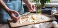 Woman is carefully holding raw homemade noodles in her hands. Process of cooking handmade pasta in a cozy atmosphere Royalty Free Stock Photo