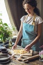 Woman is carefully holding raw homemade noodles in her hands. Process of cooking handmade pasta in a cozy atmosphere Royalty Free Stock Photo