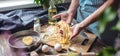 Woman is carefully holding raw homemade noodles in her hands. Process of cooking handmade pasta in a cozy atmosphere Royalty Free Stock Photo