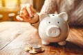 A woman carefully places a coin into a piggy bank, reflecting thoughtful financial habits and saving