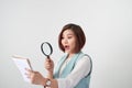 Woman carefully reading business contract with magnifying glass