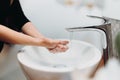 Woman carefully washing hands with soap and sanitiser in home bathroom
