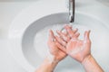 woman carefully washing hands with soap and sanitiser in home bathroom. top view, details of hygiene