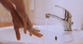 Woman carefully washing her hands with soap and water in bathroom. Detail of woman`s hands washing on sink.Slow motion