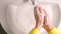 Woman carefuly washing her hands with soap in the bathroom