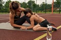 Woman caress son lay on her knees on sports ground
