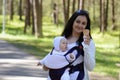 Woman caring child in baby carrier