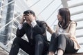 The woman caring the frustrated businessman with failed business sitting on the stairs in downtown