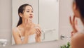 Woman caring of her beautiful skin on the face standing near mirror in the bathroom Royalty Free Stock Photo