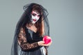 Woman in a carnival costume of a witch or a dead bride holding a Royalty Free Stock Photo