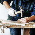 Woman carpenter using hammer pushing nail on a wood Royalty Free Stock Photo