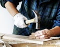 Woman carpenter using hammer pushing nail on a wood Royalty Free Stock Photo