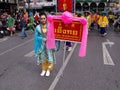 A woman carries a banner in the parade in a Festival of the Clans of the Chinese community of Bangkok