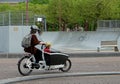 Woman carries a child in a bicycle trolley Royalty Free Stock Photo