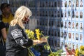 Woman carries flowers to Memory Wall of Fallen Defenders of Ukraine in war in Eastern Ukraine 2014-2020. Kyiv, Ukraine