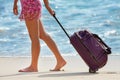 Woman carries your luggage near the blue ocean Royalty Free Stock Photo