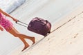 Woman carries your luggage at sandy beach Royalty Free Stock Photo