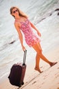 Woman carries your luggage at sandy beach Royalty Free Stock Photo