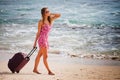 Woman carries your luggage at sandy beach Royalty Free Stock Photo