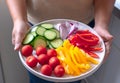 A woman carry a plate of mixed vegetable colorful salad