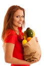 Woman carrying a bag full of various fruits isolated over white Royalty Free Stock Photo