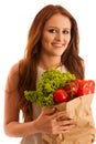 woman carrying a bag full of various vegetables isolated over white background Royalty Free Stock Photo