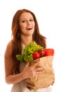 woman carrying a bag full of various vegetables isolated over white background Royalty Free Stock Photo