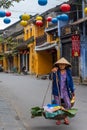 Woman carrying basket in Hoi An