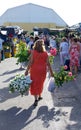 Woman carrying a bunch of flowers through a Spanish market