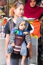 Woman carrying a child in a harness