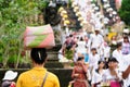 The woman is carrying gifts for Hindu gods on the head in the woven baske