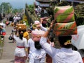 The woman is carrying gifts for Hindu gods on the head in the woven baske