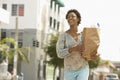 Woman Carrying Grocery Bag While Walking On Street