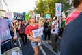 A woman carrying her baby and a sign that reads Mini Rebel, at an Extinction Rebellion protest march