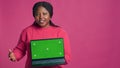 Woman carrying laptop with green screen