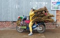 Woman carrying large parcel on a motorbike