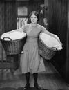 Woman carrying laundry baskets Royalty Free Stock Photo