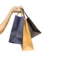 Woman carrying paper shopping bags isolated on white background. Adult woman hand hold three shopping bag with blue and brown Royalty Free Stock Photo