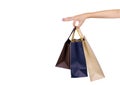 Woman carrying paper shopping bags isolated on white background. Adult woman hand hold three shopping bag with blue and brown Royalty Free Stock Photo