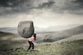 Woman carrying a rock on mountain