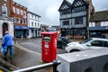 Woman Carrying Shopping Walking Past A Royal Mail Parcel Post Box