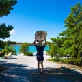 Woman carrying a surfboard in a horizontal position atop their head waking to the beach Royalty Free Stock Photo