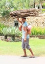 Woman carrying wood and baby