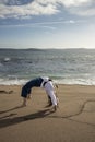 woman cartwheeling in kimono on the beach