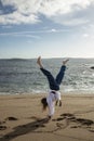 woman cartwheeling in kimono on the beach