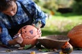 Woman carve pumpkins for Halloween outdoor